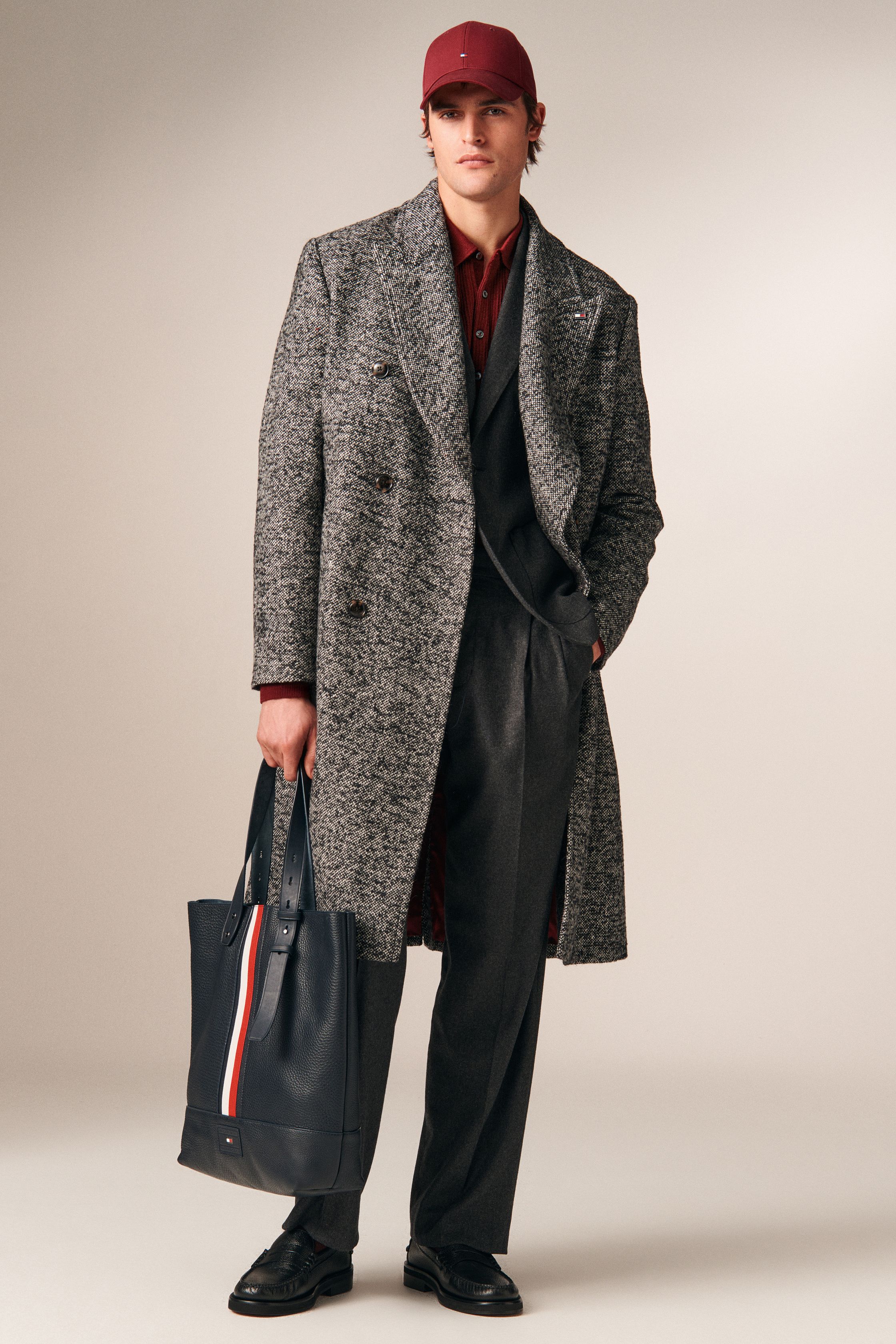 Tommy Hilfiger 26FW 男装回到品牌最擅长的美式学院与都市绅士语境。条纹针织、飞行夹克、羊羔毛外套与双排扣大衣共同勾勒出成熟却不老派的美式精英形象。色彩以海军蓝、酒红、驼色为核心，强化可靠、易穿的商业属性。系列不追求先锋表达，而是精准回应全球市场对“经典升级版”的现实需求-顽石频道趋势研究